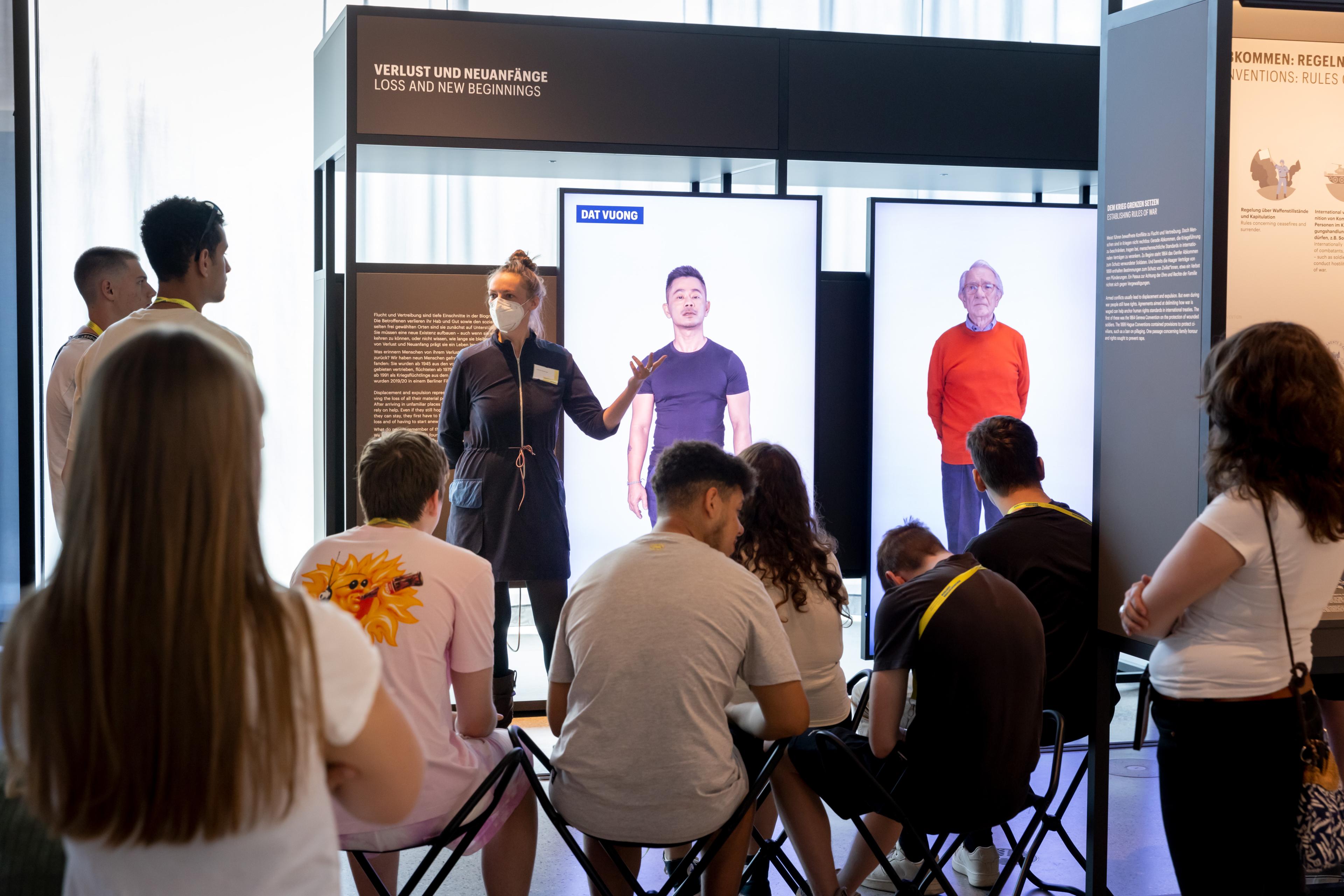 Frau erklärt etwas vor einer Gruppe von Personen