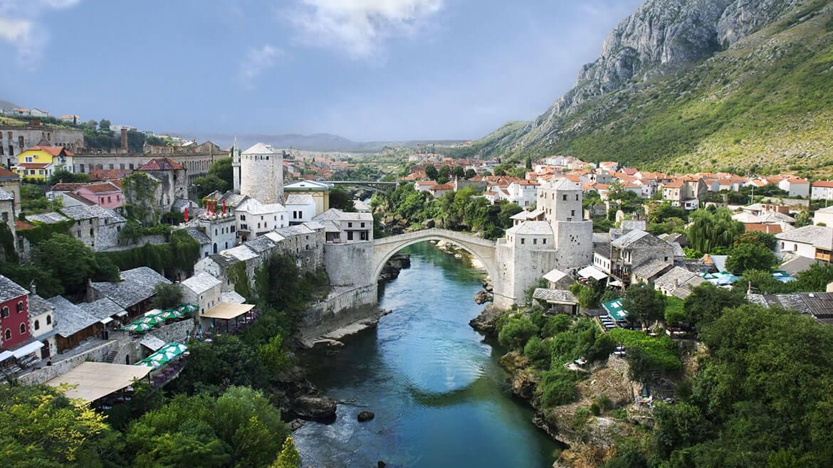 Brücke von Mostar, 2007: Seit dem 16. Jahrhundert spannt sich die Alte Brücke über den Fluss Neretva in Mostar. 1993 wurde sie während des Krieges in Bosnien völlig zerstört. Drei Jahre später begann man mit der Rekonstruktion der Brücke und eröffnete sie 2004 erneut. Sie verbindet den östlichen, bosnisch geprägten Stadtteil mit dem kroatisch dominierten Westen und symbolisiert die Hoffnung auf ein friedliches Zusammenleben aller ethnischen und religiösen Gruppen. Brücke von Mostar, 2007: Seit dem 16. Jahrhundert spannt sich die Alte Brücke über den Fluss Neretva in Mostar. 1993 wurde sie während des Krieges in Bosnien völlig zerstört. Drei Jahre später begann man mit der Rekonstruktion der Brücke und eröffnete sie 2004 erneut. Sie verbindet den östlichen, bosnisch geprägten Stadtteil mit dem kroatisch dominierten Westen und symbolisiert die Hoffnung auf ein friedliches Zusammenleben aller ethnischen und religiösen Gruppen.
