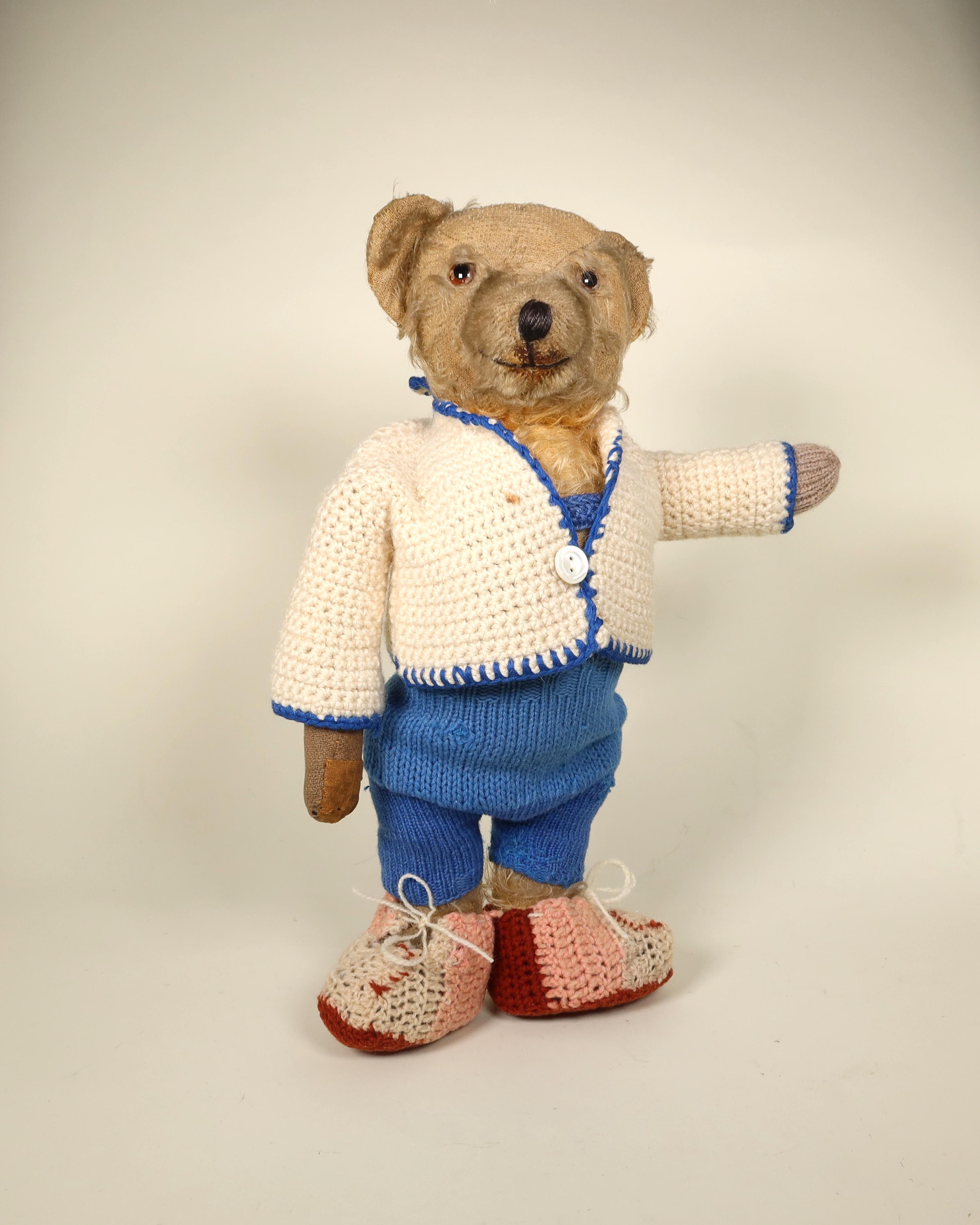 Objektfoto eines Teddys mit weißer Jacke und blauer Hose.
