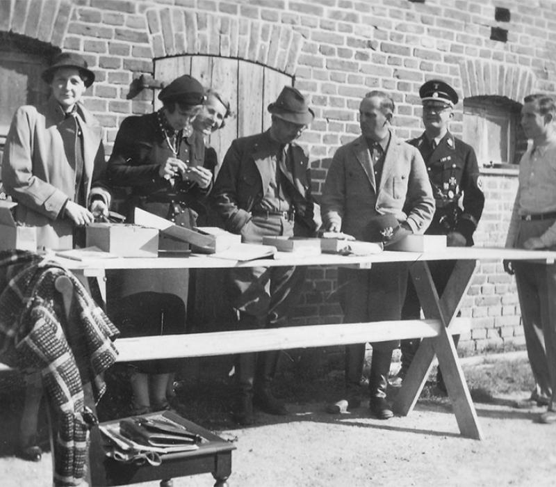 Schwarz-Weiß Menschen stehen an einem Tisch 