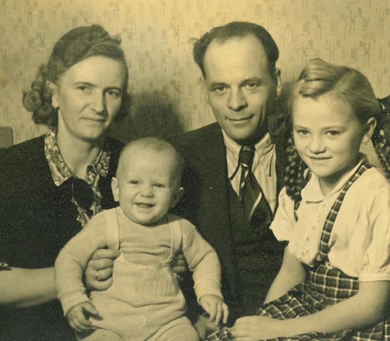 Familienfoto in schwarz-weiß Aufnahme mit einem Mann, einer Frau und zwei Kindern.