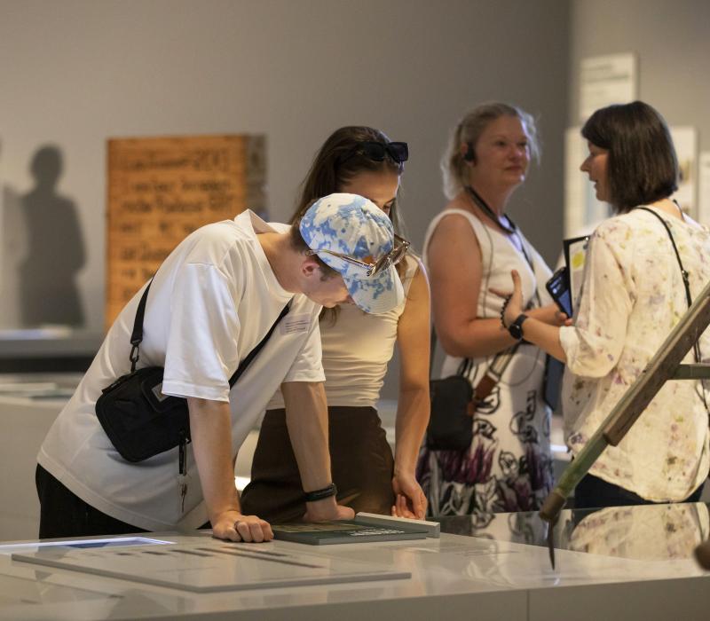 Drei Personen die bei einer Führung des Museums sind