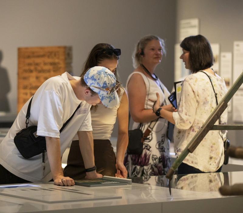 Drei Personen die bei einer Führung des Museums sind